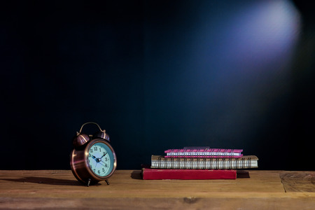 Still life old text book and alarm clock on table.の写真素材