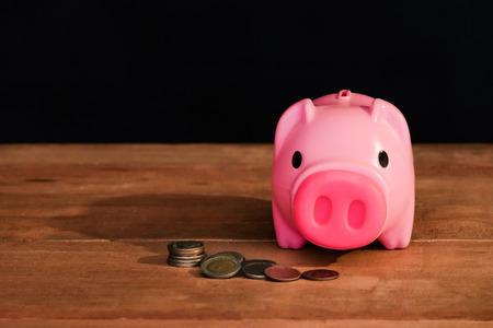Still life piggy bank and coin stack on table.
