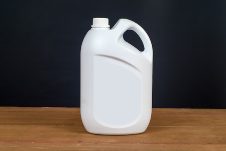 White plastic bottle container on wood table .