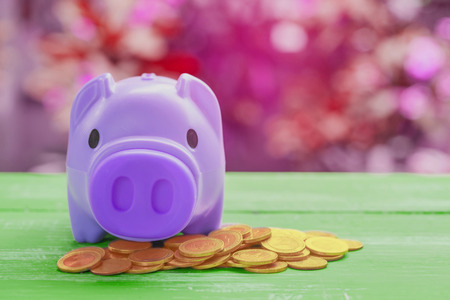 pink piggy bank over coins stack, saving money concept.の写真素材