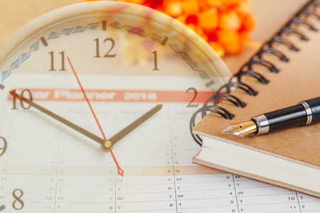 personal organizer or planner with fountain pen on clock