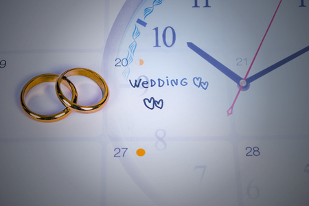 Word Wedding to Reminder Wedding day with Wedding ring on calendar planning and clockの写真素材