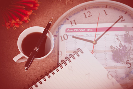 personal organizer or planner with fountain pen and hot coffee on clockの写真素材