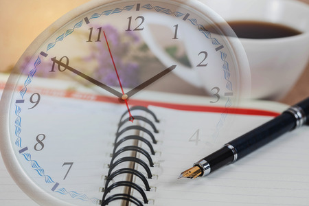 personal organizer or planner with fountain pen and hot coffee on clockの写真素材