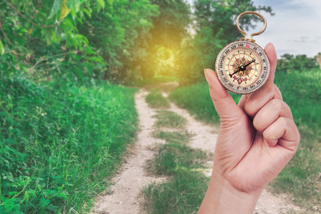 Compass in hand with nature background ,traveler concept.の写真素材
