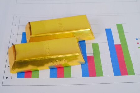 Heap of gold bars on business chart background Banking concept.