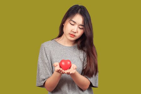 young woman holding red heart sign in hand,love concept.