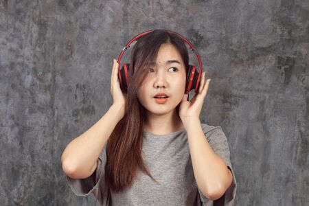 young woman wearing headset enjoying new audio tracks playing in smartphone.の写真素材