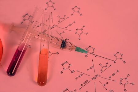 Red solution in syringe with dropper and chemical formula background , science concept.の写真素材