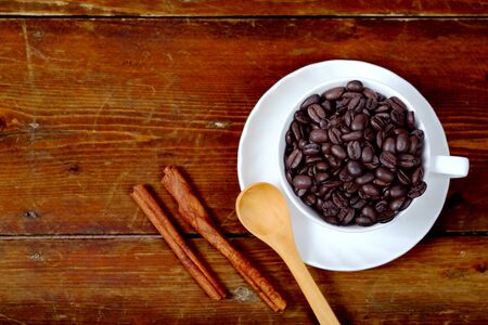 Coffee bean in white coffee cup on old wood background.の写真素材