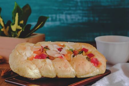Mixed fruit bread with almond flakes on color wood background,food concept.