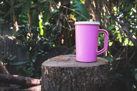 pink cooler cup on wooden in backyard .の写真素材