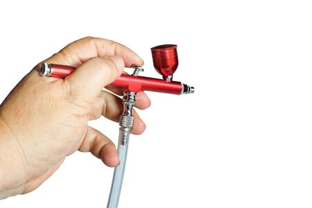 Red airbrush spray tool in hand for paintingg hobby or work for art .の写真素材