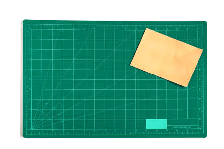 Green grid cutting matt or pad with color paper note on background.の写真素材