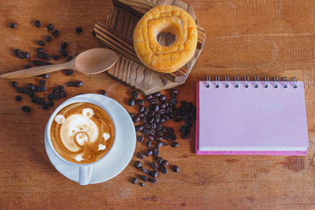 Hot cappuccino art with fresh coffee bean on table.の写真素材
