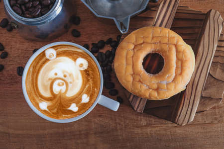 Hot cappuccino art with fresh coffee bean on table.の写真素材