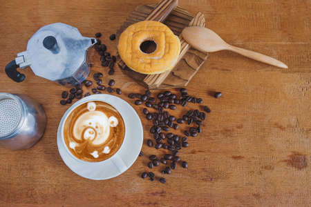 Hot cappuccino art with fresh coffee bean on table.の写真素材