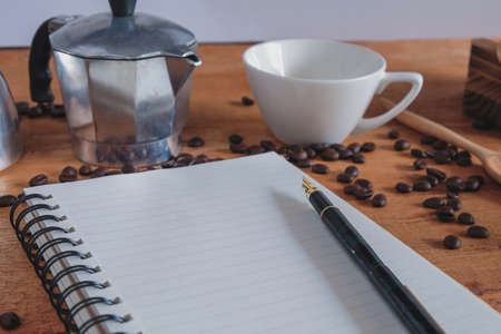 Booknote and pen on tabe with fresh coffee maker set .の写真素材