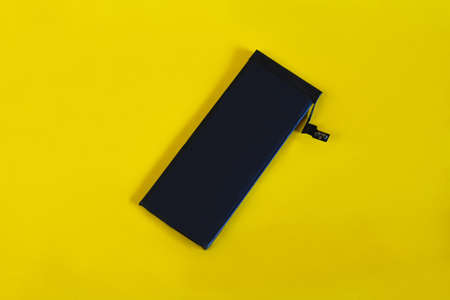 Swollen lithium ion polymer battery inside a mobile phone on  background.
