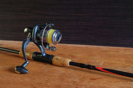 Fishing spinning reel on wooden table.