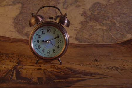 Classic Alarm clock on vintage paper map background.の写真素材