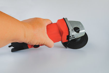 Powerful angle grinder with abrasive disk on background.