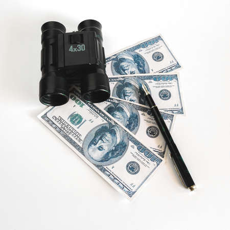 Telescope or binocular and US dollar banknote money on table.Business Vision concept.