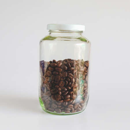 Coffee beans in glass bottles on white background.の写真素材