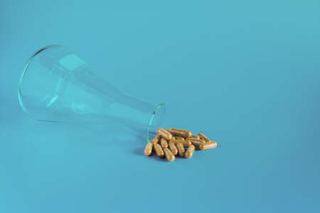 Medical concept - Science bottle with scattered herb capsule pills.の写真素材