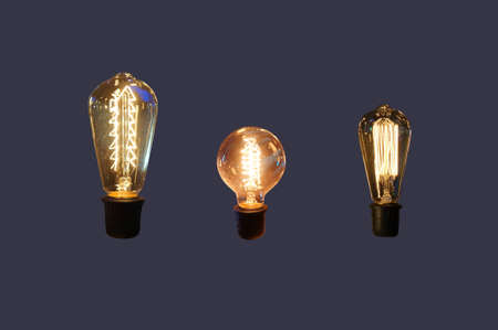 Vintage hanging light bulb over dark background.