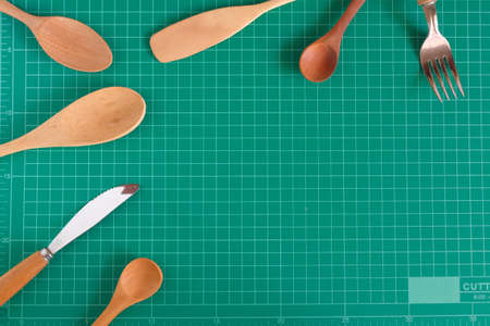 Kitchenware and wood spoon on cutting mat background.の写真素材