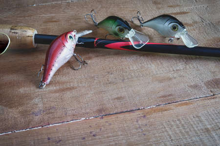 Fishing tackle - fishing spinning, hooks and lures on wooden table.の写真素材