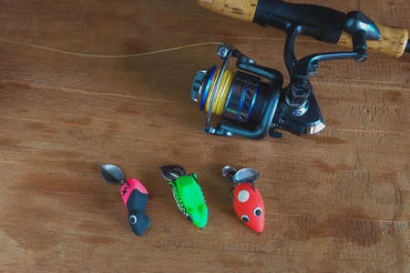 Soft plastic frog lure with fiishing spinning  ,Fishing bait on wooden background.の写真素材