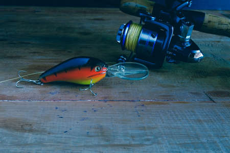 Fishing tackle - fishing spinning, hooks and lures on wooden table.の写真素材