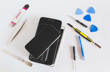 Technician or engineer disassembling components broken smartphone.