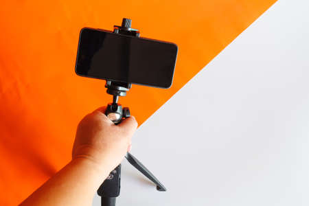 Mobile phone on a tripod with a clear display for color paper background.の写真素材