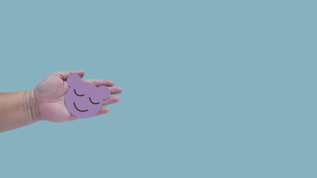 Hand holding color paper cut with face sign on color background .の写真素材