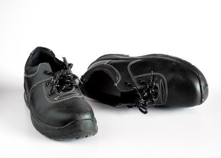 Black and dirty pair of children's shoes on background.