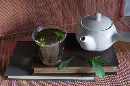 Fresh green tea with tea leaves and tea pot .の写真素材