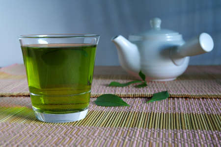 Fresh green tea with tea leaves and tea pot .の写真素材