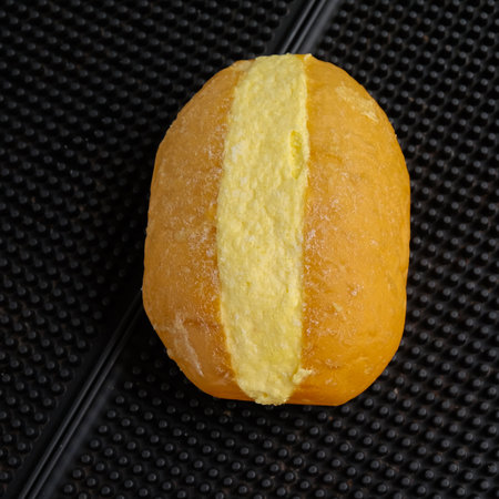Buns with butter on top, over black mat background.の写真素材
