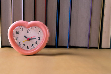 Red heart clock in front of open book , love and brightness concept.