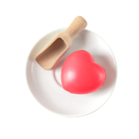 Red heart with woden spoon on dishware.の写真素材