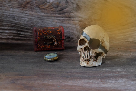 The pirate skull with old box on brown wooden background.の写真素材