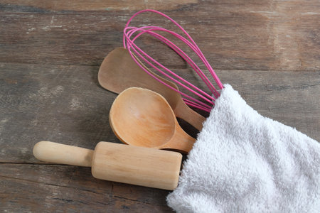 Set of utensils in towel on wooden.