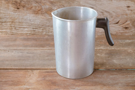 Empty metal pitcher or jug  on wooden table.の写真素材