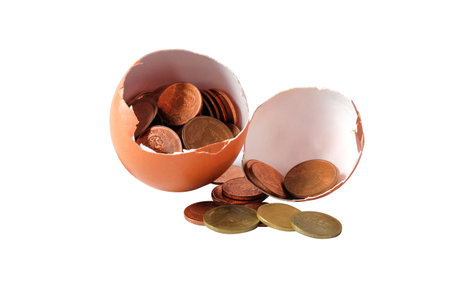 A coin in egg shell on white background.の写真素材