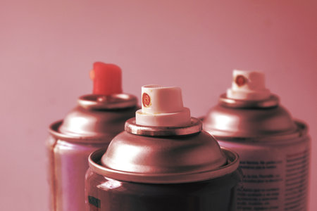Used cans of spray paints on color background.の写真素材