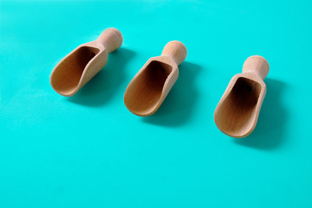 Three wooden spoons on a color background. Top view.の写真素材