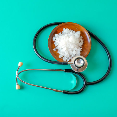 Sea salt on wooden dish with stethoscope. concept of healthy lifestyle.の写真素材